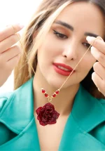 نمای نزدیک گردنبند عقیق سرخ زنانه مدل بهدیس با گل رز مینیاتوری طبیعی کاور شده با رزین UV و مهره‌های عقیق سرخ روی زنجیر استیل طلایی