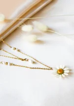 گردنبند مروارید ساده و شیک دوریس با گل طبیعی بابونه کاور شده با رزین UV و زنجیر استیل طلایی روی زمینه سفید پارچه‌ای