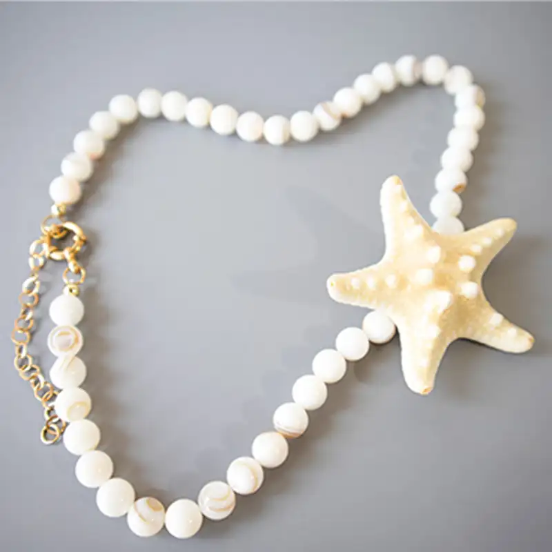 گردنبند ستاره دریایی مدل دریاناز با مهره های صدف کرم سفید و آویز بزرگ ستارهای طلایی