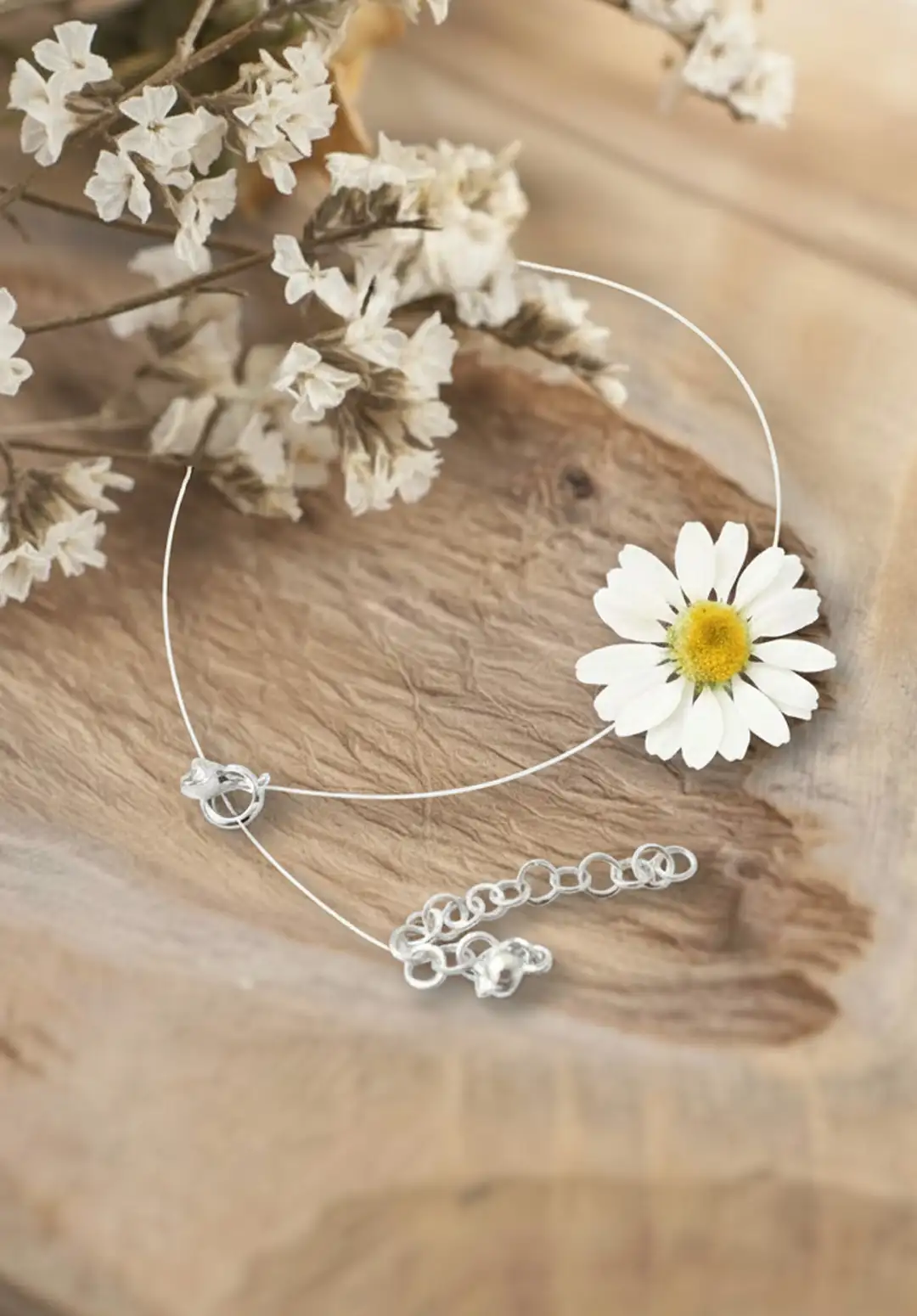 چوکر گل بابونه طبیعی هایا از برند سانیا، ساخته شده با گل بابونه واقعی کاور شده با رزین UV، بند نامرئی و قفل استیل روی زمینه چوبی.